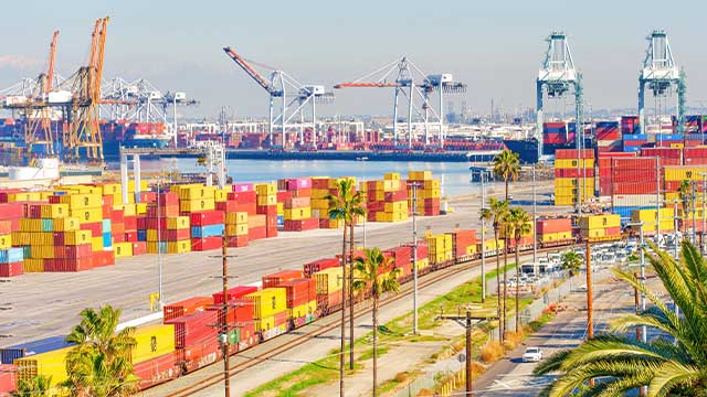 Yellow and red containers at Long Beach port. You can see cranes in the distance